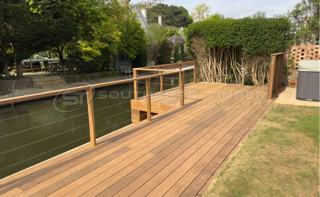 Ipe 21 x 145mm grooved hidden-fix decking installed beside a riverside garden, showcasing the smooth finish, rich brown tones and clean concealed fixing system supplied by Southgate Timber.